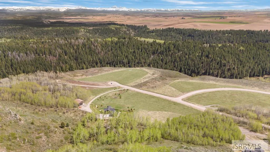 Aerial of Twin Rivers Ranch with distant Tetons and farmland.